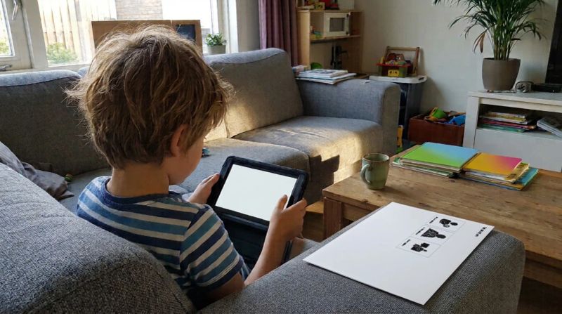 Kind met tablet naast een strip met picto's voor schermtijd